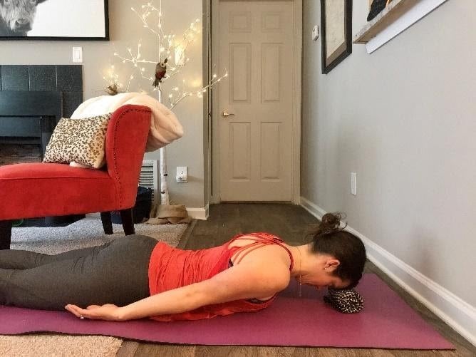 Female lying on her stomach performing chin tuck to reduce headaches