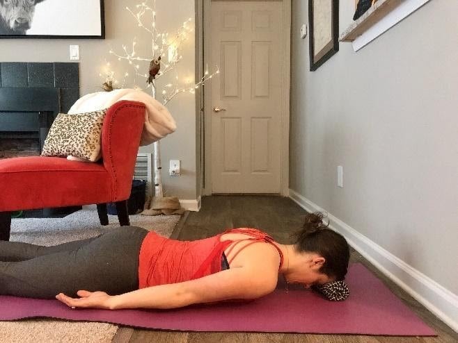 Female lying on her stomach with good posture to reduce headaches