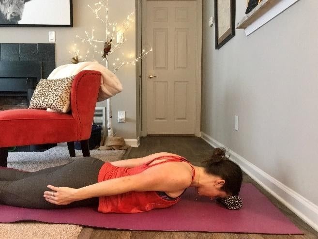 Female performing shoulder blade squeeze to improve posture and reduce headaches